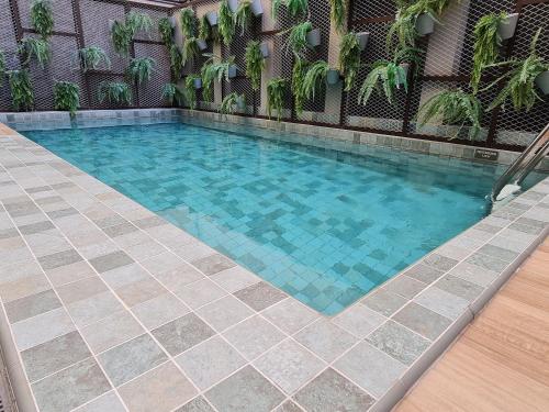 a swimming pool with a tiled floor and blue water at RioDowntown - Rede Nosso Cantinho in Rio de Janeiro