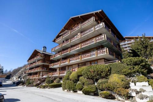 an apartment building with bushes in front of it at Les Busards 18 in Nendaz