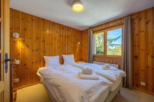 a bedroom with a large bed with wooden walls at Les Busards 18 in Nendaz