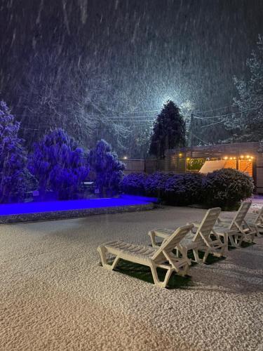 um par de bancos na neve à noite em Guest house Shulc em Mizhhirʼʼya
