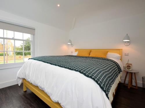 a white bedroom with a large bed and a window at 1 Bed in Rutland Waters 60672 in Oakham