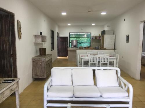 a living room with a white couch and a kitchen at Cabaña La Niña Cande-Punta Bolivar in San Antero