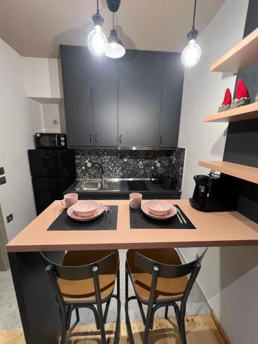 a kitchen with two chairs and a table with two plates at Βερβερίτσα in Monodendri