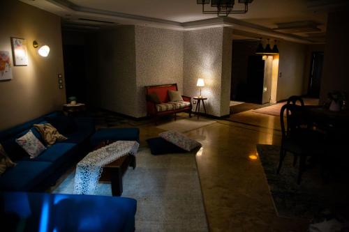 a living room with blue couches and a couch at Cairo Heliopolis Apartment in Cairo