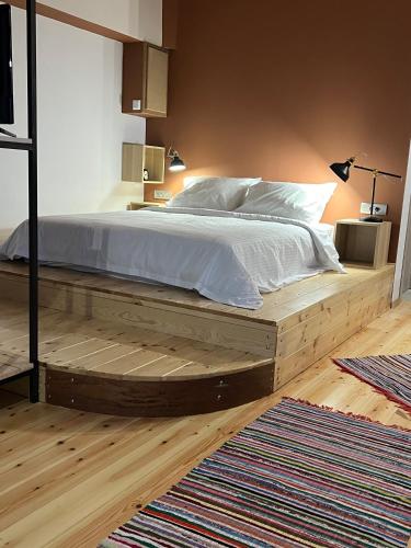 a bedroom with a large bed with a wooden platform at Βερβερίτσα in Monodendri