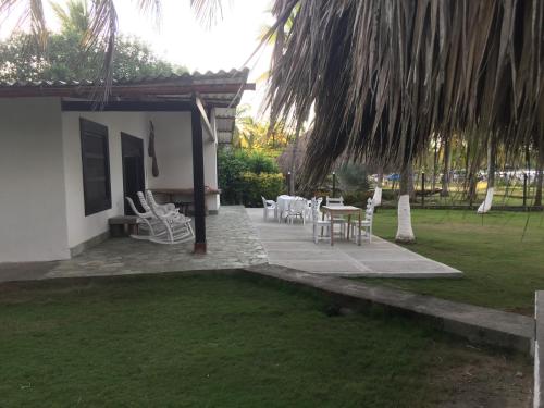 a patio with chairs and a table in a yard at Cabaña La Niña Cande-Punta Bolivar in San Antero