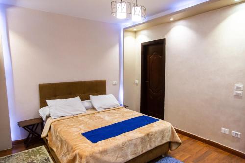 a bedroom with a bed with a blue blanket at Cairo Heliopolis Apartment in Cairo