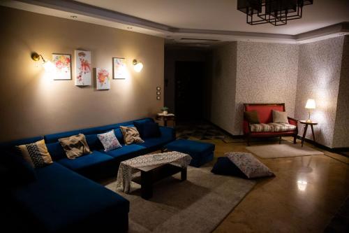 a living room with a blue couch and a chair at Cairo Heliopolis Apartment in Cairo