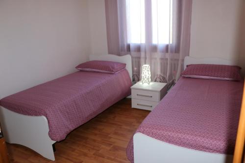 a bedroom with two beds and a window at Appartamenti via Calnova in Noventa di Piave