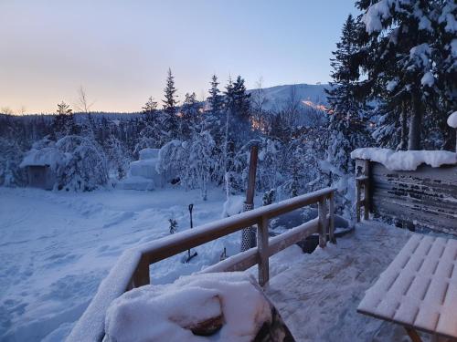 a bench covered in snow next to a fence at Mysig stuga i vemdalssskalet in Vemdalen