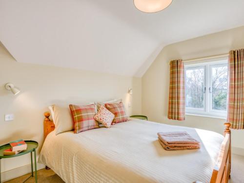 a bedroom with a bed and a window at 3 Bed in Wareham 76648 in East Stoke
