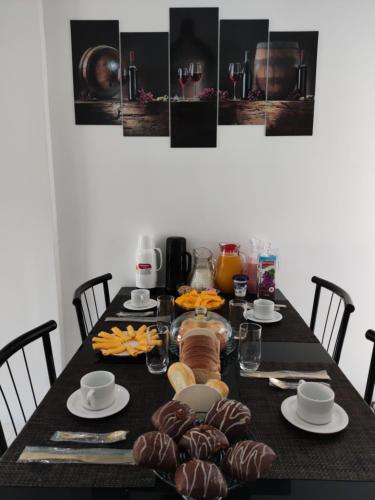 een eettafel met een zwarte tafel met eten bij Apartamento luxo, há 5min do centro de Itaipava in Petrópolis