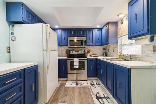una cucina con armadi blu e frigorifero bianco di Flamingo Bay Cottage cottage a Saint James City