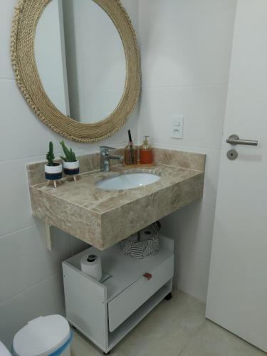 a bathroom with a sink and a mirror at Apto à beira-mar em Arraial do Cabo in Arraial do Cabo