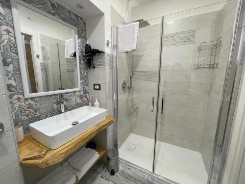La salle de bains blanche est pourvue d'un lavabo et d'une douche. dans l'établissement CASA MASADA, à Naples