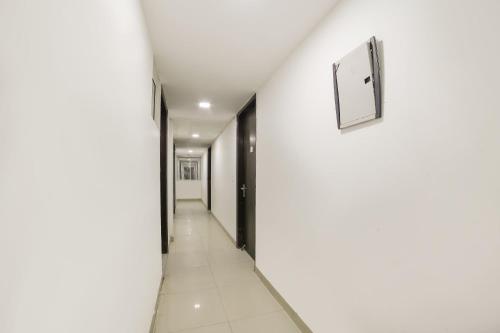 a corridor of an office building with white walls at OYO My Comfortable Hotel in New Delhi