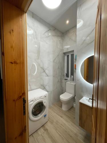 a bathroom with a washing machine and a toilet at Maltese Balcony in St Julian's