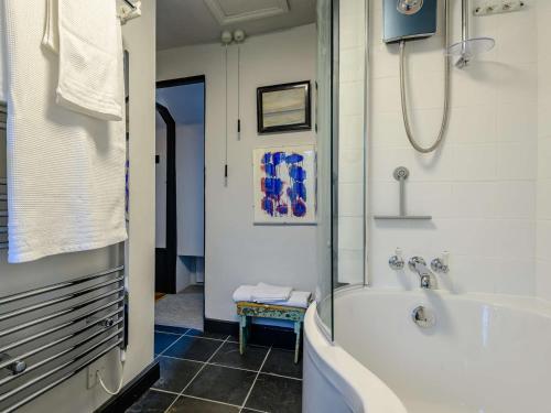 a bathroom with a bath tub and a sink at 1 Bed in Bridport 89687 in Bridport