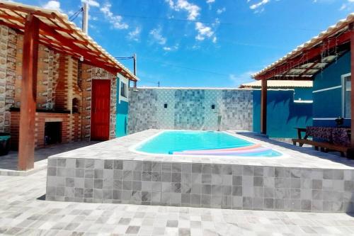 einen Pool in der Mitte einer Terrasse mit einem Haus in der Unterkunft Refúgio dos Lagos. in Cabo Frio