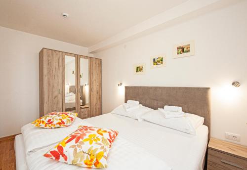 ein Schlafzimmer mit zwei Betten mit weißen Laken und Kissen in der Unterkunft Kraljevi Cardaci in Kopaonik