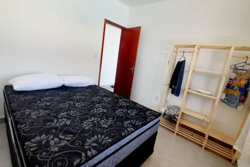 um pequeno quarto com uma cama e um closet em Refúgio dos Lagos. em Cabo Frio