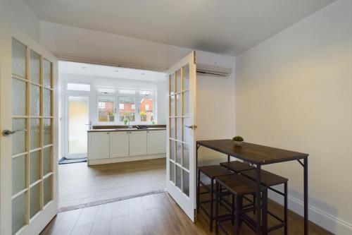 cocina con paredes blancas y mesa en una habitación en Modern 3 Bed House, en Dagenham