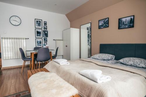 ein Schlafzimmer mit einem großen Bett und einem Tisch mit Stühlen in der Unterkunft Kamieniec No5 Apartments in Zakopane