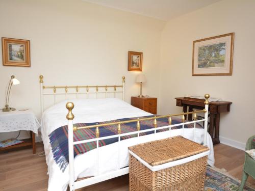 a bedroom with a white bed and a table at 2 Bed in Carnoustie 58026 in Monikie