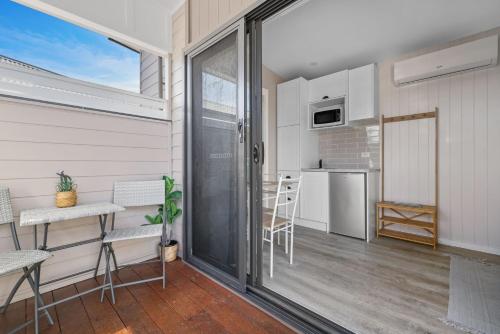 a room with a balcony with a table and chairs at Tiny House Stays House 4 in Sanctuary Point