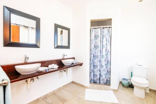 a bathroom with two sinks and a toilet at Spotless 3 BRs house w/ pool in Roatán