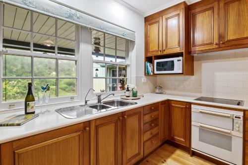 a kitchen with wooden cabinets and a sink at Spottiswoode - 215 Barclay Road, Myponga in Myponga