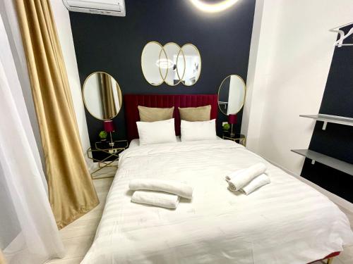 Un dormitorio con una gran cama blanca con espejos en Metropole Apartments - Old City, en Bucarest