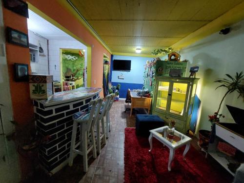 MACONDO apartamento turistico tematico في زيباكويرا: غرفة معيشة مع بار وطاولة وكراسي