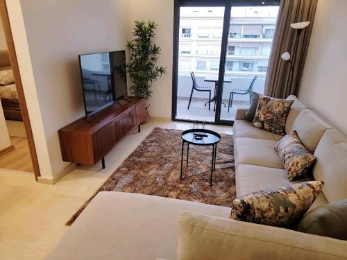 ein Wohnzimmer mit Sofa und Klavier in der Unterkunft Appartement Parc Mohammedia in Mohammedia