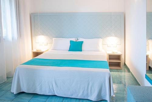 un grande letto in una stanza con due lampade di Pietrablu Resort & Spa - CDSHotels a Polignano a Mare