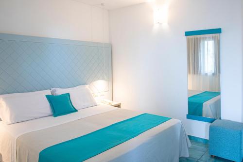 a bedroom with a large bed with a blue headboard at Pietrablu Resort & Spa - CDSHotels in Polignano a Mare