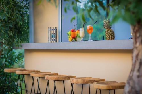 a row of stools with drinks on a bar at Lindos Breeze Beach Hotel in Kiotari