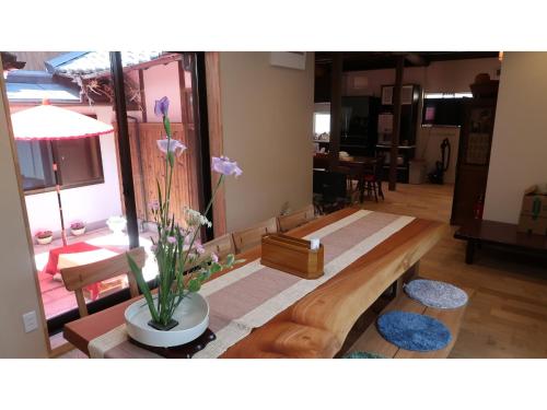 a living room with a wooden bench and flowers at Uji Tea Inn - Vacation STAY 27208v in Uji