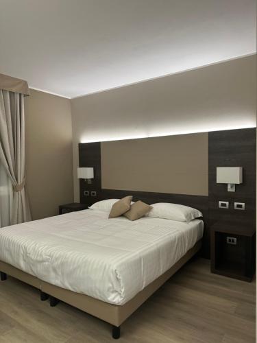 1 dormitorio con 1 cama blanca grande y 2 almohadas en Hotel Arthur, en Solignano Nuovo