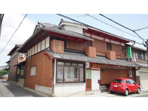 un'auto rossa parcheggiata davanti a un edificio di Uji Tea Inn - Vacation STAY 27219v a Uji