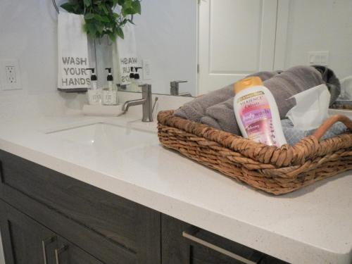 a bathroom counter with a basket of towels and a sink at Experience the Best of Houston from our Modern Urban Oasis in Houston