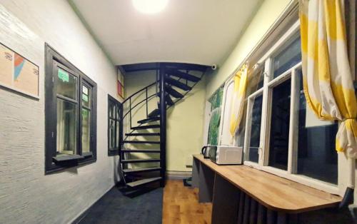 a hallway with a spiral staircase in a building at Roots Hostel in Chişinău