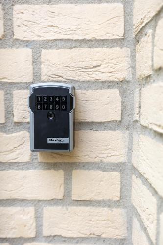 a clock on the side of a brick wall at luxe vakantiehuisje - sauna - natuur - strand in Ewijk