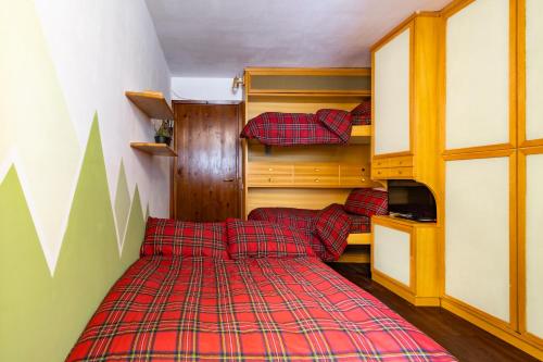 una camera con due letti e una coperta rossa a quadri. di BeSt Marmotta a Sestriere