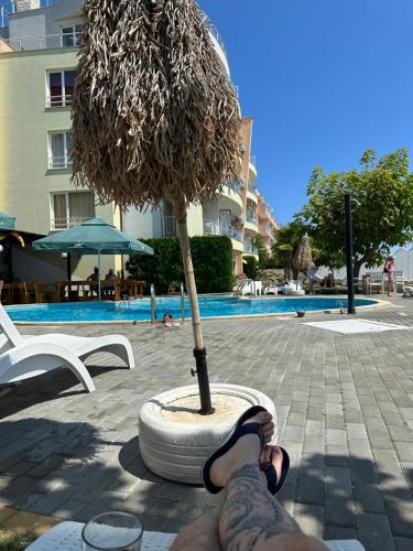 a person with their feet up next to a small tree at Alex Beach in Elenite