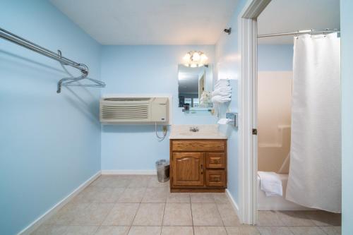 a bathroom with a sink and a air conditioner at Stage Run by the Sea in Ogunquit