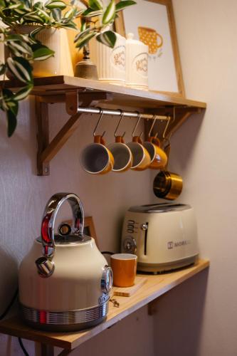 a tea kettle and a toaster on a shelf at la foret in Metsovo