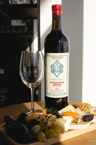 a bottle of wine and a glass on a table at Hotel Roshe Gudauri in Gudauri