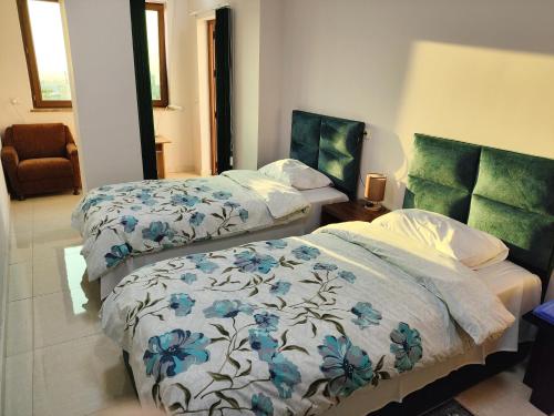 a bedroom with two beds and a chair at APEX Rest house of 10 rooms and pool in Yerevan