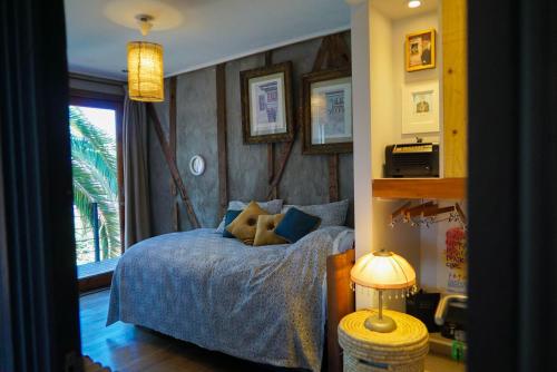 ein Schlafzimmer mit einem Bett, einem Fenster und einer Lampe in der Unterkunft Patio Ferreiro B&B in Cartagena